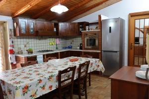 Il comprend une cuisine équipée d'une table et d'un réfrigérateur. dans l'établissement Attico La Terrazza, à Viagrande