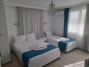 a hotel room with two beds and a couch at Huzur Hotel in Siğacık