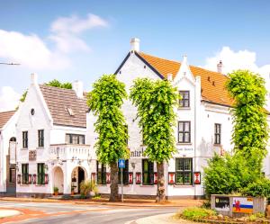 a large white building with ivy growing on it at Hotel Nieuw Antiek in Helden