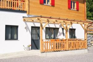 dom z drewnianą werandą i tarasem w obiekcie Rollstuhlfreundliche Ferienwohnung in ruhiger Lage- Panorama Terrasse, 2 SZ w mieście Pöllauberg