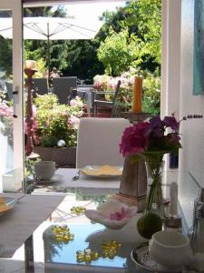 een tafel met een vaas met bloemen op een patio bij Hotel Ambiente et Art in Düsseldorf