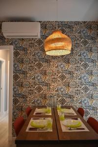 a dining room with a table and a patterned wall at Sweet Arco Rosa Zona Centro in Cádiz