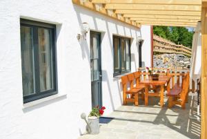 taras ze stołem i krzesłami na budynku w obiekcie Rollstuhlfreundliche Ferienwohnung in ruhiger Lage- Panorama Terrasse, 2 SZ w mieście Pöllauberg