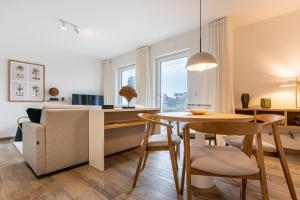 cocina y sala de estar con mesa y sofá en App 22, Strandresidenz Dünenperle, en Kühlungsborn