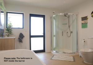 a bathroom with a shower and a toilet at Marlborough Wine Barrel Cabins in Blenheim