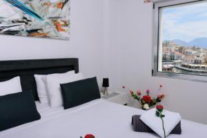 a bedroom with a white bed with a window at Luxury Lake View in Agios Nikolaos