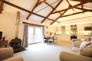 a living room with a couch and a table and a kitchen at The Forge at Trevadlock Manor in Lewannick