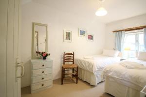 a bedroom with two beds and a chair and a mirror at The Forge at Trevadlock Manor in Lewannick