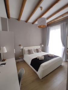 una camera da letto con un grande letto bianco e una finestra di Manno Rooms Affittacamere a Cagliari