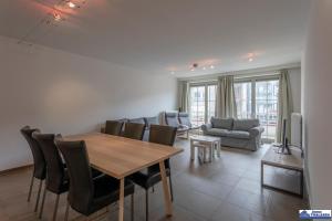 Una sala de estar con mesa de comedor y sillas. en Wilcé 0102, en Koksijde