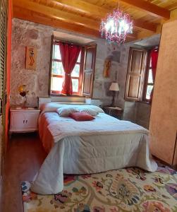 a bedroom with a bed and a chandelier at A Casa da Carballa in Ponteareas