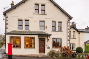 a white house with a red fire hydrant in front of it at The Old Post Office in Grange Over Sands