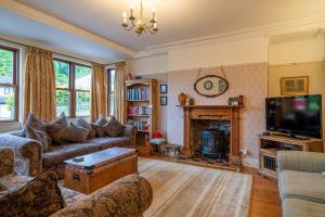 a living room with a couch and a fireplace at The Old Post Office in Grange Over Sands