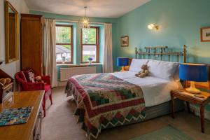 a bedroom with a bed with a teddy bear on it at The Old Post Office in Grange Over Sands