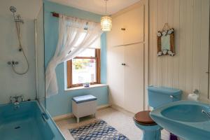 a bathroom with a blue tub and a sink at The Old Post Office in Grange Over Sands +35 photos