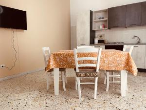 uma mesa de jantar e cadeiras com uma mesa e uma cozinha em Nausicaa Beach and Town em Agropoli