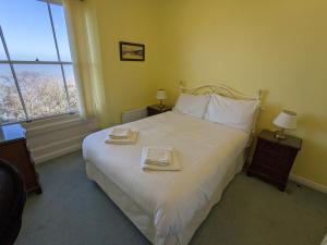 a bedroom with a large bed with two towels on it at Sea View in Shanklin