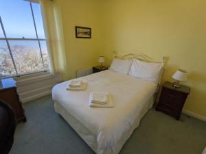 een slaapkamer met een groot bed en 2 handdoeken bij Sea View in Shanklin