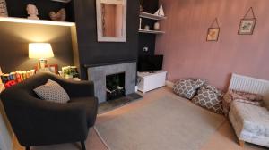 Una sala de estar con chimenea y un sofá. en The Moorings, en Saint Helens