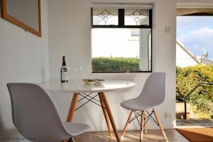 uma mesa branca e cadeiras num quarto com uma janela em Bonito em Ventnor