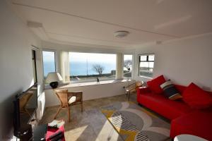 uma sala de estar com um sofá vermelho e uma grande janela em Bonito em Ventnor