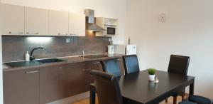 a kitchen with a table and chairs and a sink at APARTMÁN***BRATISLAVA in Bratislava
