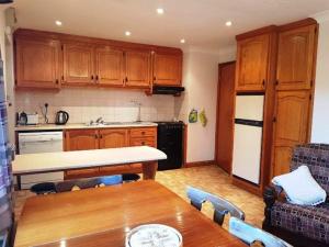 a kitchen with wooden cabinets and a wooden table with a dining room at Waterside Cottage, Cashel in Galway