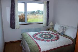 a bedroom with a bed and a window at Waterside Cottage, Cashel in Galway