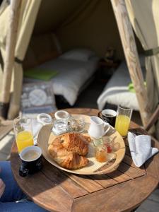 uma mesa com um prato de comida e bebidas em Camping de la Forêt Seasonova em Sillé-le-Guillaume