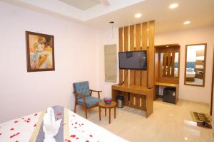 a living room with a bed and a tv at JM Vistaraa in Bareilly