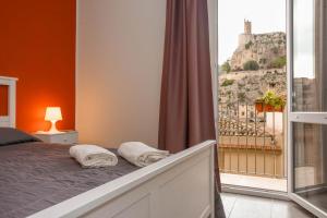 a bedroom with a bed with a view of a mountain at La Finestra Sul Castello - Modica Panoramic Flats in Modica