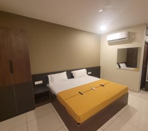 a bedroom with a bed with a yellow blanket at M Square in Vellore