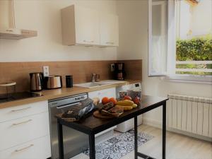a kitchen with a table with fruit on it at Gite de la rivière avec patio et parking centre ville in Le Mans
