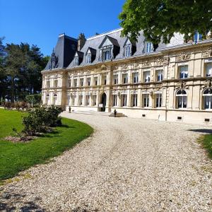 un grande edificio con un vialetto di fronte ad esso di Domaine de Bertheauville a Paluel