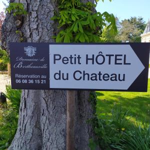 a sign for a hotel cu chateau next to a tree at Domaine de Bertheauville in Paluel