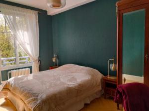 1 dormitorio con cama y pared verde en Clos Terre-lune, en Nuits-Saint-Georges
