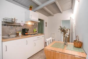a kitchen with white cabinets and a wooden counter top at La Finestra Sul Castello - Modica Panoramic Flats in Modica