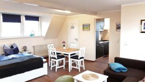 a bedroom and a living room with a bed and a table at Küstenhuus-Katy in Glowe