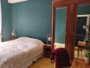 een slaapkamer met een bed en een blauwe muur bij Clos Terre-lune in Nuits-Saint-Georges