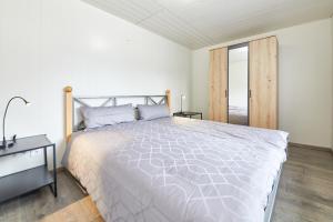Habitación blanca con cama grande y escritorio. en Haus Blanka, en Brauneberg