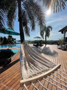 a hammock sitting on a deck next to a pool at The Endless Summer Resort in Bumbang