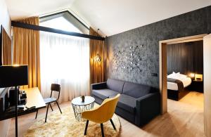 a living room with a couch and a bed at Hotel Zugbrücke Grenzau GmbH in Höhr-Grenzhausen
