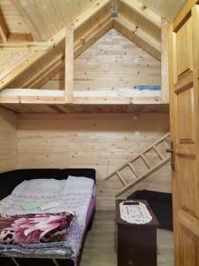 an attic room with a bunk bed and a ladder at kamp Bungalovi sase apartman in Višegrad