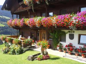 Un edificio con muchas flores. en Gruberhof, en Reith im Alpbachtal