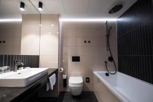 a bathroom with a sink and a toilet and a tub at The Gold Bank in Prague