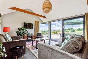 a living room with couches and a large glass door at Hoods in Bridport