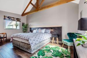 a bedroom with a large bed and a green chair at Hoods in Bridport