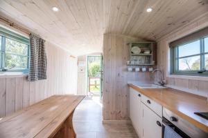 a kitchen with wooden walls and a wooden counter top at Honeysuckle Farm Holidays by Stay In Suffolk in Woodbridge