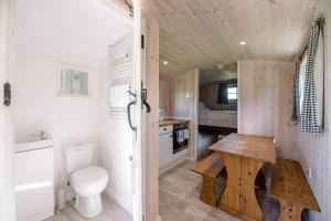 a small bathroom with a toilet and a wooden table at Honeysuckle Farm Holidays by Stay In Suffolk in Woodbridge