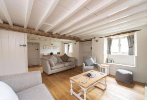 a living room with a couch and a table at Vicarage Cottage in Powerstock